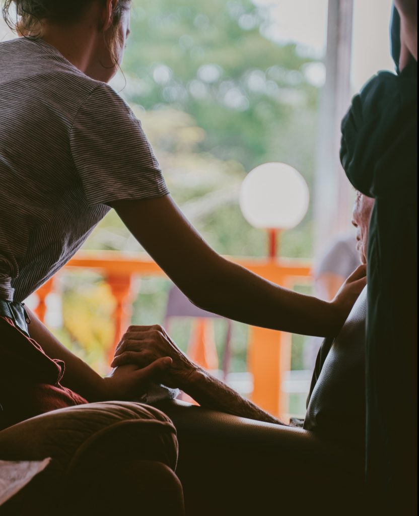 Young woman holding older womans hand
