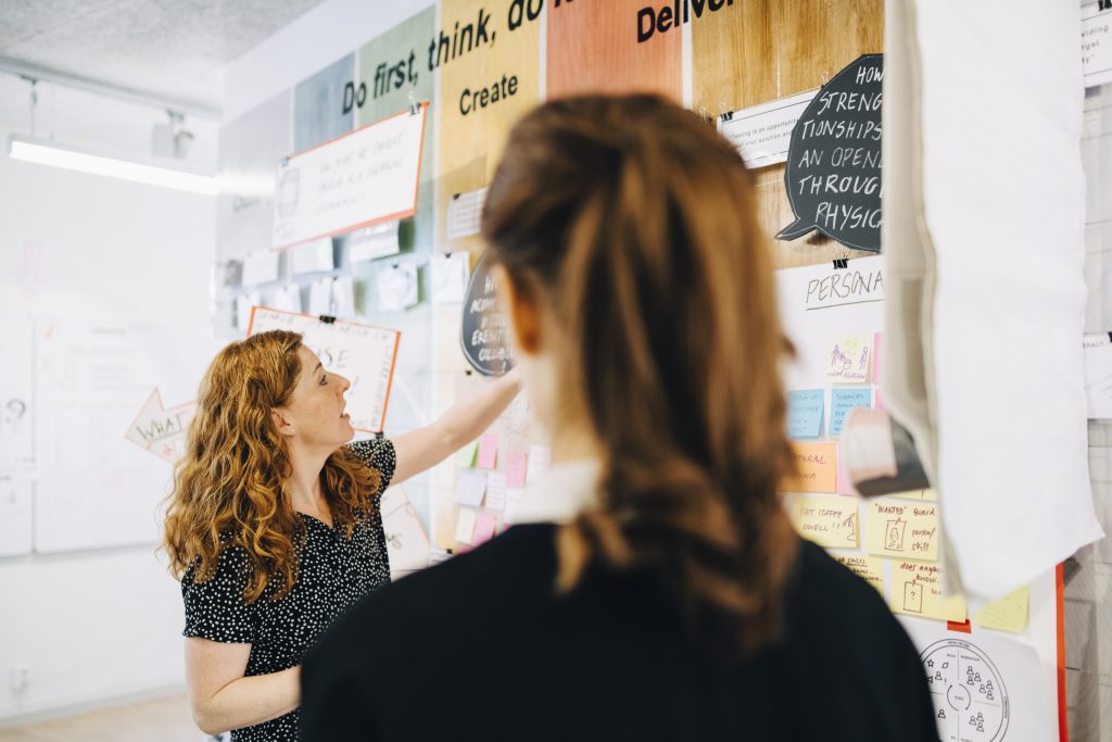 Team interacting with prototypes at Openlab's design thinking wall.